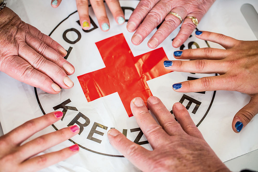 Rotes Kreuz mit Händen